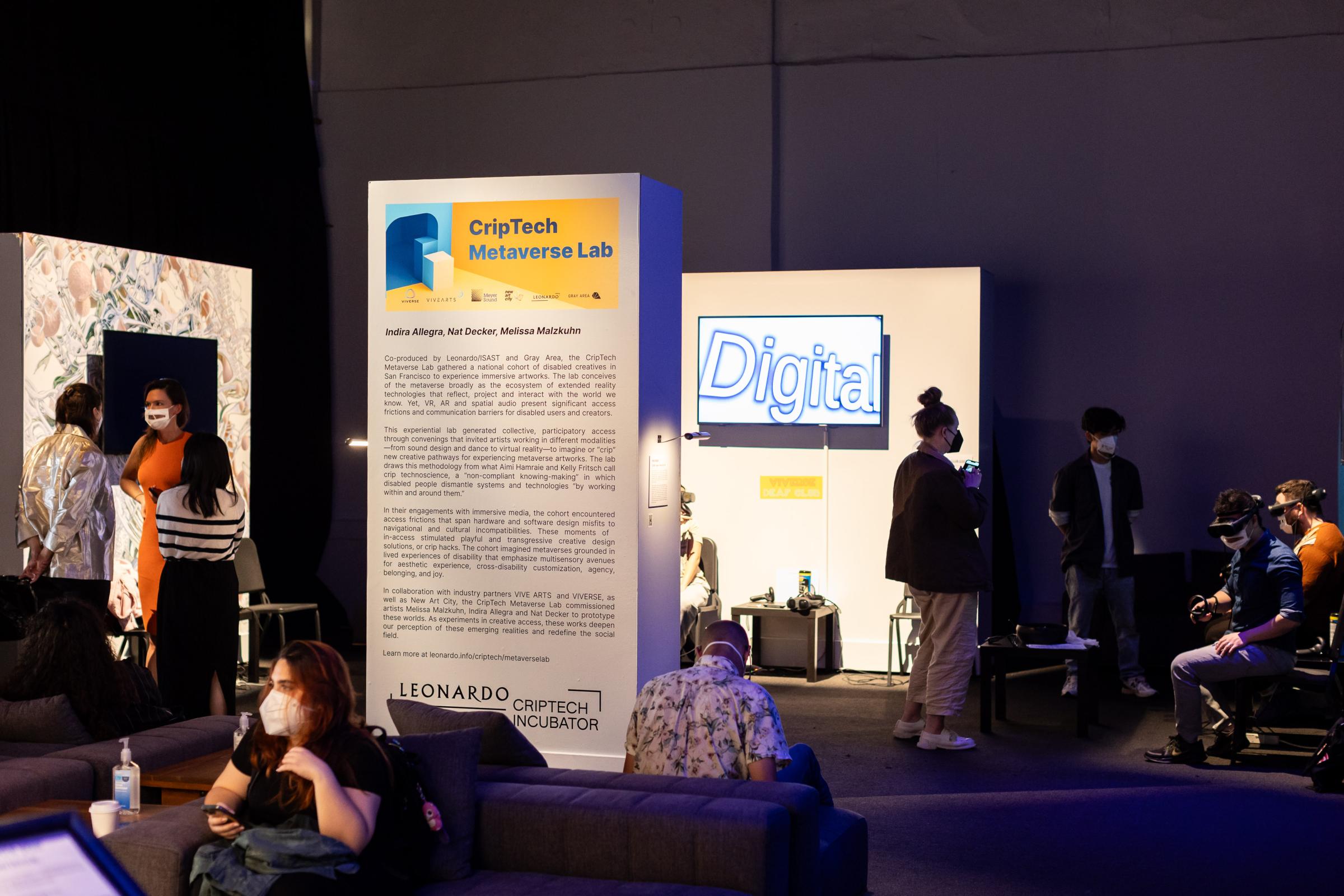 Gallery in gray area space with different attendees trying VR prototypes while seated.