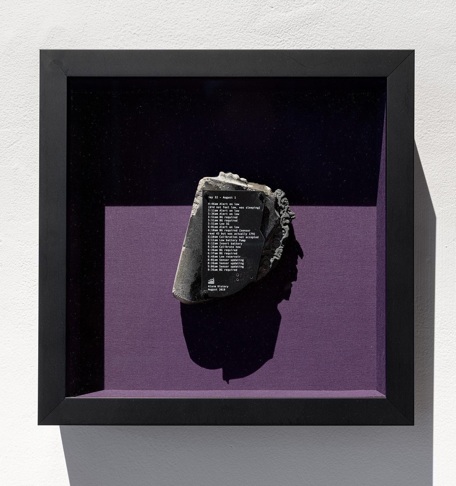 artwork of a concrete block with text on top against a mauve background encased in a black frame