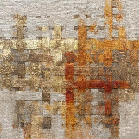 An abstract artwork featuring woven fabric-like material containing horizontal and vertical bands of gold, white, gray, and reds. The composition feels both minimal and tactile, balancing precision with organic materiality.
