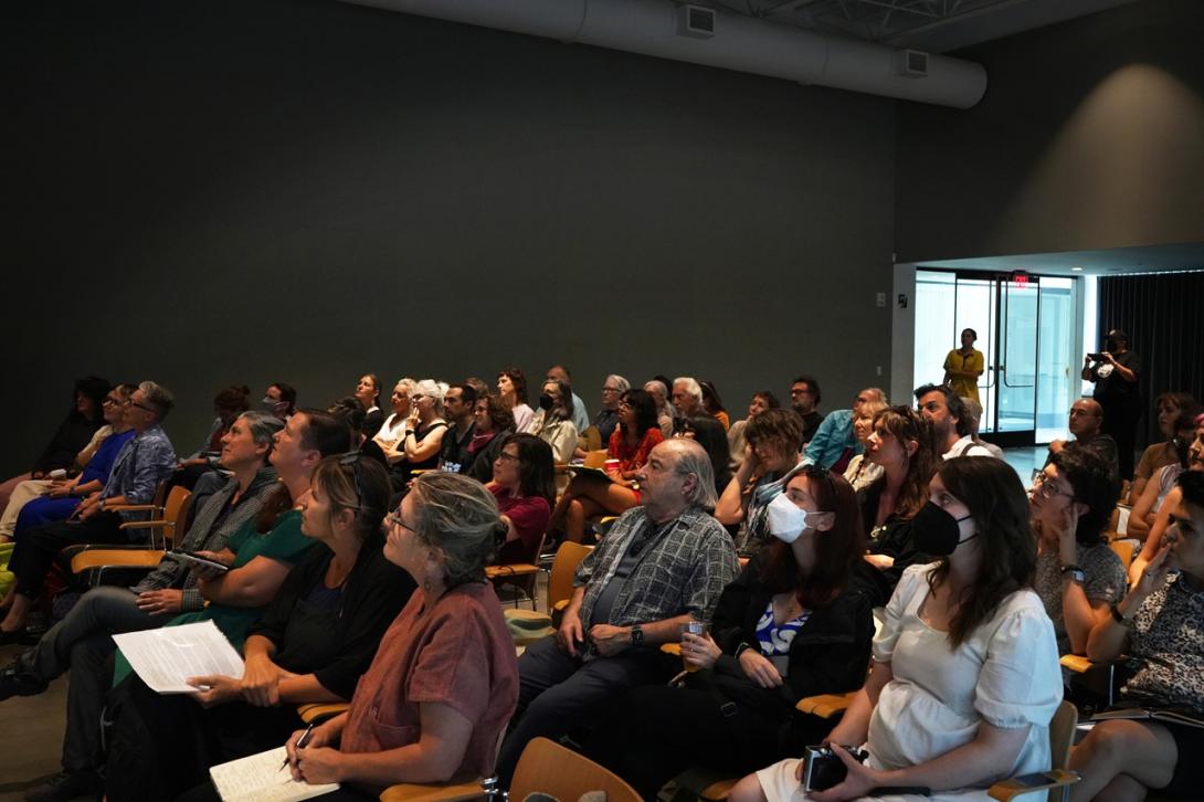 Seated audience looking toward a speaker off-screen.