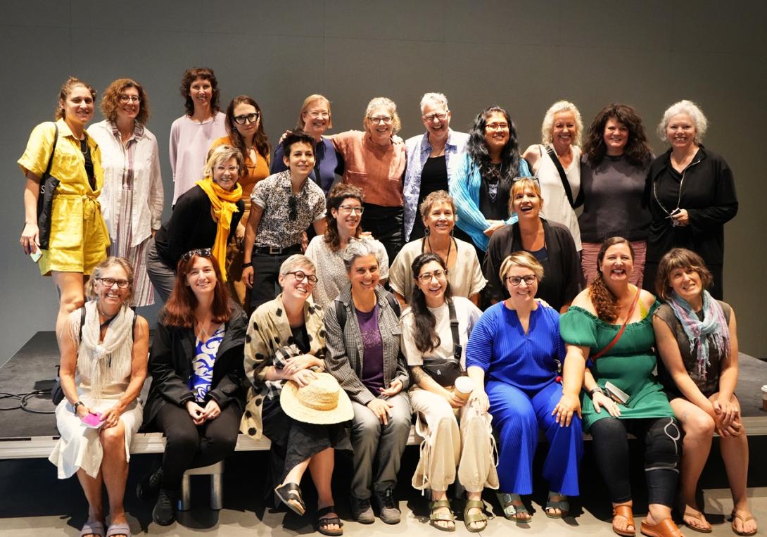 Group photo of smiling people standing in three rows.