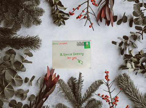 Leonardo 2020 Holiday Gif. Animation of the six 2020 journal issues sliding out of an envelope on a holiday themed background of snow and evergreen boughs.