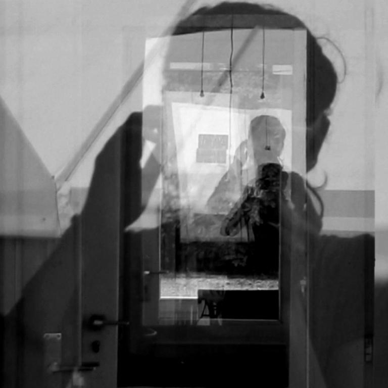 Photograph of reflected silhouette through multiple windows